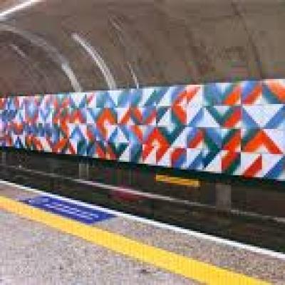 Mural artístico em estação de metrô com padrões geométricos coloridos
